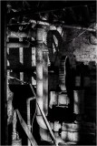 A dark, shadowy corner filled with rusted pipes and machinery.