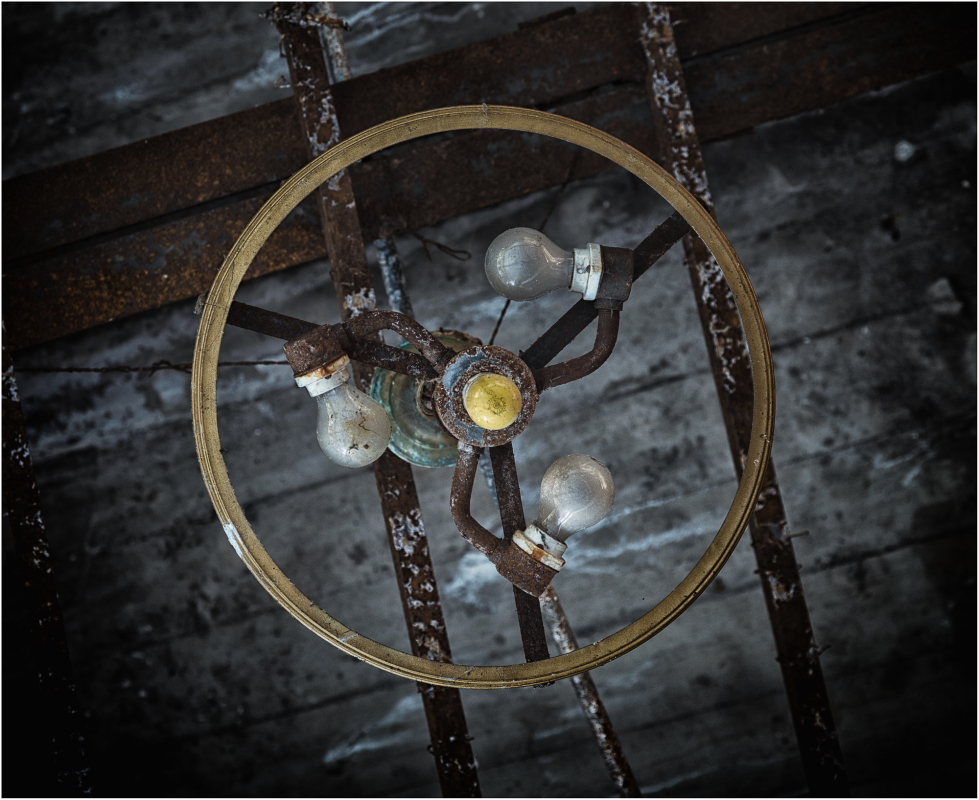 Chandelier hangs from a decaying ceiling