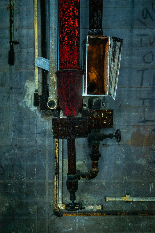 An assemblage of pipes and valves, aged and rusted, exuding an aura of forgotten dread.