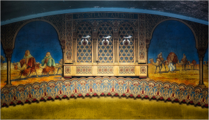 Decorative mural featuring figures on camels and intricate patterns