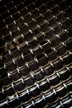 A close-up of worn theater seats, faded and empty, echoes of past performances linger.