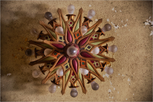 Intricate wooden ceiling ornament with vibrant colors and glowing bulbs.