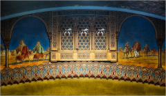 Decorative mural featuring figures on camels and intricate patterns