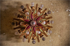 Intricate wooden ceiling ornament with vibrant colors and glowing bulbs.