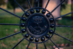 Intricate black ironwork circles, a vintage emblem at the center, surrounded by sharp spikes.