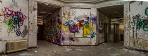 Vibrant graffiti on decaying walls of an abandoned building, evoking a haunting atmosphere.