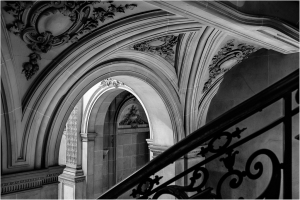 Black and white image of ornate architectural details in a staircase area.
