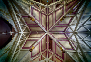 Intricate geometric ceiling design with wooden beams and colored patterns.