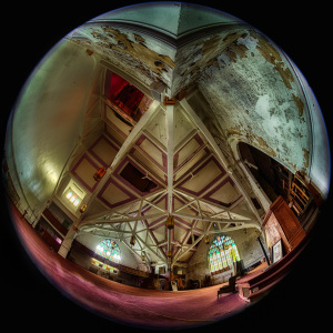 A grand, decaying hall with vibrant stained glass and peeling walls, echoing forgotten tales.