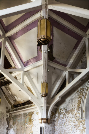 Intricate ceiling beams converge around golden fixtures, whispering secrets of forgotten spaces.