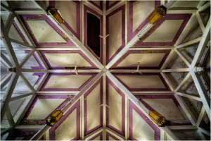 Intricate ceiling design with purple accents and wooden beams crisscrossing above.