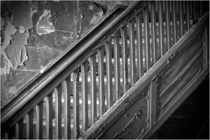 A worn staircase with peeling paint and a vintage railing, inviting yet ominous.