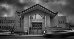 Police court facility building with cloudy sky and a person walking past.