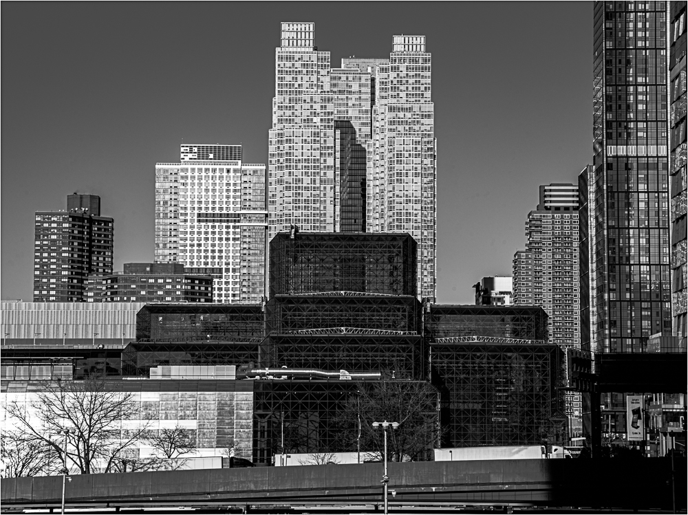 City skyline featuring modern buildings with geometric shapes and contrasting textures.