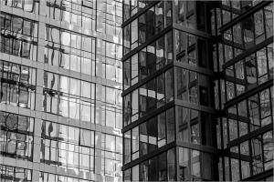 Abstract view of modern glass buildings with reflections and geometric patterns.