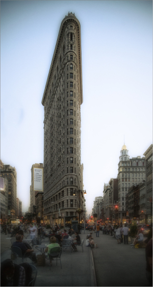 The Flatiron Building in New York City, a tall, narrow, triangular-shaped skyscraper.