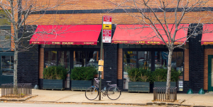 A restaurant with red awnings and a bicycle parked outside.