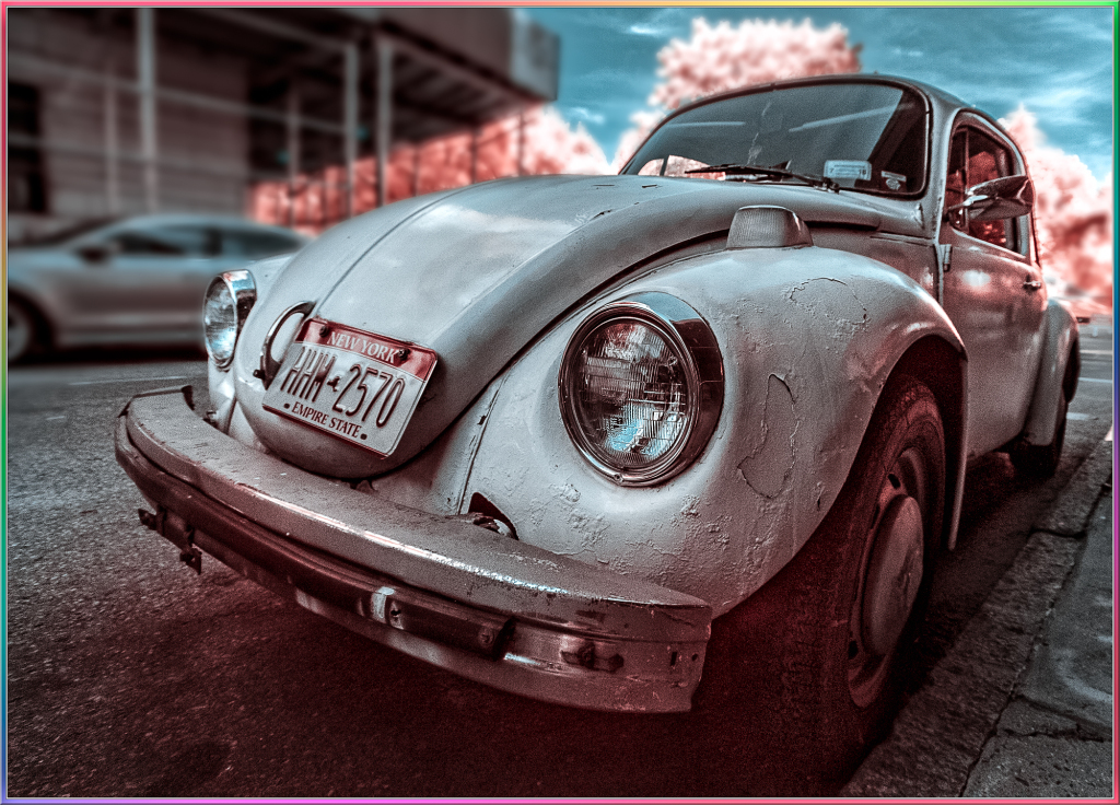 A vintage Volkswagen Beetle parked on a city street, captured in infrared.