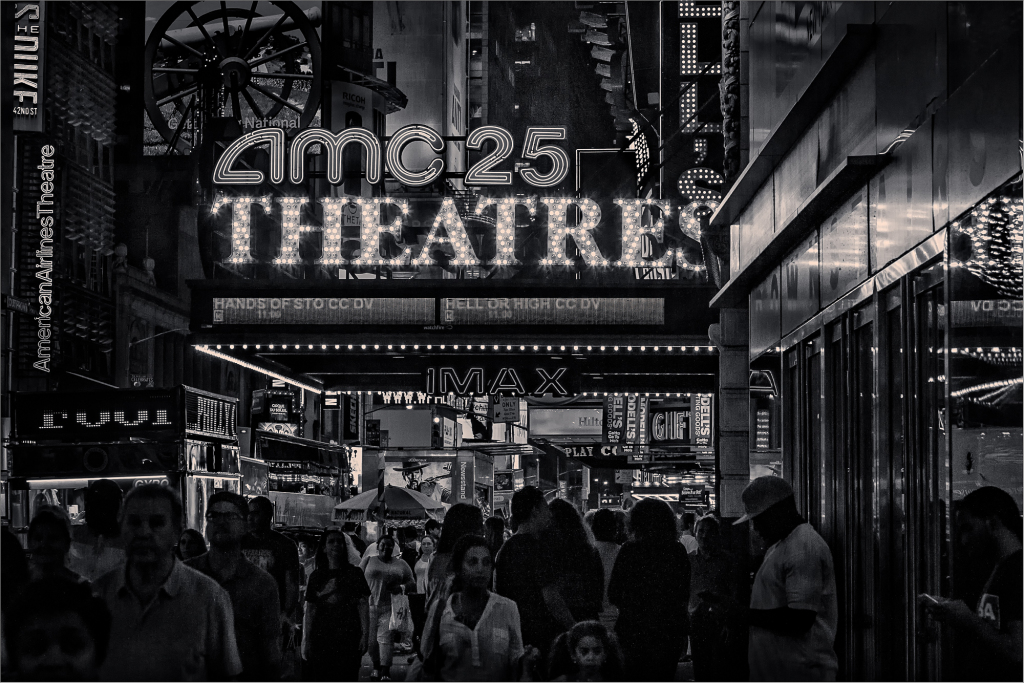 Crowd in front of AMC 25 Theatres in Times Square, New York City at night.