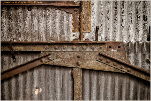 Close-up of rusted metal beams and corrugated surface textures.