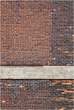 A textured wall of aged bricks in deep reds and browns, with a weathered wooden beam across the center.