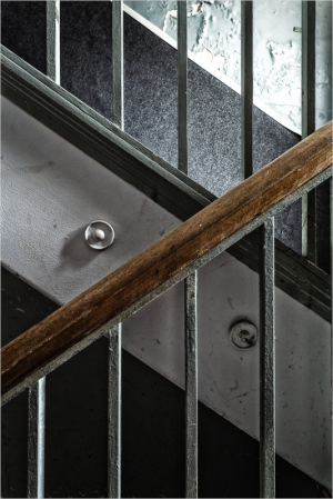 Staircase with metal railings and wooden handrail, showcasing urban infrastructure.