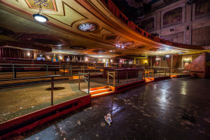 A grand, empty theater with ornate details and dramatic lighting.