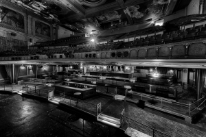Abandoned Paramount Theatre interior with empty seating and dim lighting.