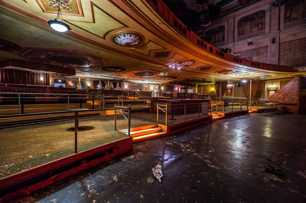 A grand, empty theater with ornate details and dramatic lighting.