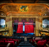 Interior of the Paramount Theatre, showcasing faded grandeur and empty seats.