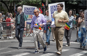 A group of people marching in a parade holding signs and flags.