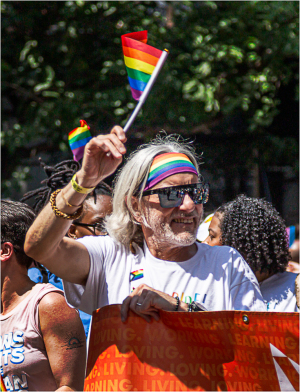 A spirited participant waves a rainbow flag at NYC Pride Day, embodying joy and celebration.