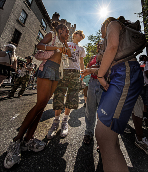 Group of friends conversing at NYC Pride day, sun shining above