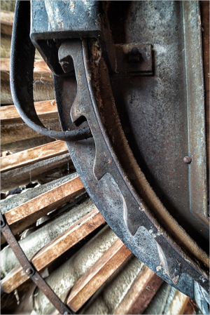 Close-up of a weathered watermill wheel with rust and wooden slats