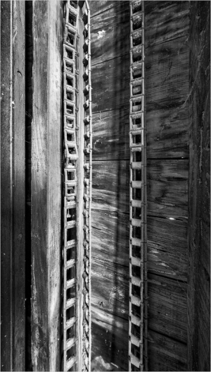 Close-up of wooden beams with intricate patterns and shadows.