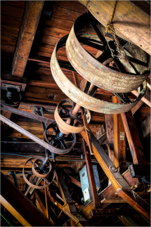 Detailed view of old machinery with wooden beams and metal gears, showing wear and history.
