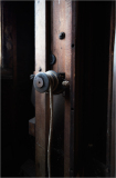 Close-up of a wooden mill mechanism with a pulley and rope.