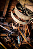 Detailed view of old machinery with wooden beams and metal gears, showing wear and history.