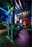 A surreal, colorful industrial scene with old machinery and beams of light.