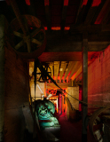 Gears and machinery bathed in a surreal glow, shadows loom in an industrial haunt.