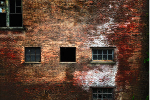 A weathered brick facade reveals time's silent touch and forgotten stories.