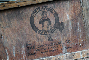 Vintage wooden crate with Scranton Lace Co. logo and cartoon character design.