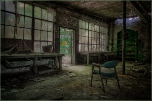 An abandoned space, where shadows stretch and light plays on decaying surfaces.