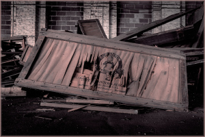An abandoned frame cradling distorted reflections amidst scattered debris.