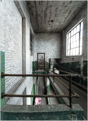 A forgotten corridor with peeling paint and a railing, exuding industrial nostalgia.