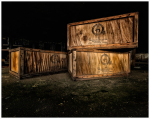 Weathered wooden crates rest in darkness, echoes of industry linger.