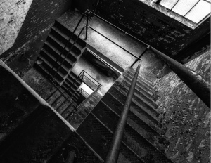 A foreboding descent into shadowy depths, metal and stone entwined.
