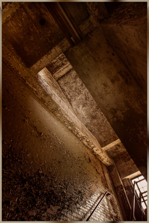Abandoned service corridor showcasing crumbling concrete and dust-laden beams.