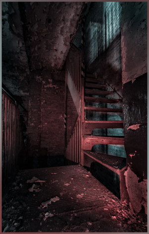 Dimly lit stairway in a derelict building with peeling walls and debris scattered.