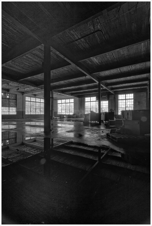 Empty space with large windows and reflections on the floor, hinting at a forgotten past
